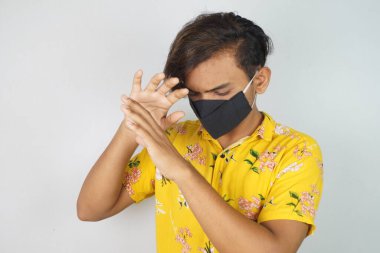 Maske takan genç bir adam, yüz maskesi, korona savaşçıları, dezenfektan görüntüsü kullanıyor. Vastav Kharat .