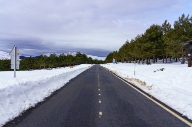 Bulutları ve mavi gökyüzü olan yüksek dağ yolu. Morcuera Madrid.