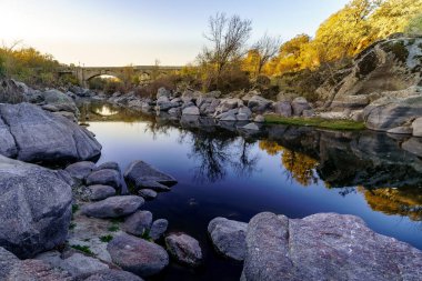 Nehirli kış manzarası, sudaki yansımalar ve büyük kayalar. Canencia 'da. Gredos