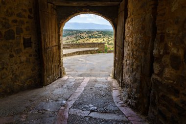 Segovia 'daki Pedraza Kalesi. Taştan yapılmış eski ortaçağ şövalyeleri sarayı. İçi taştan caddeleri, yeşil bitkileri, kemerleri ve tünelleri olan bir kale. İspanya.