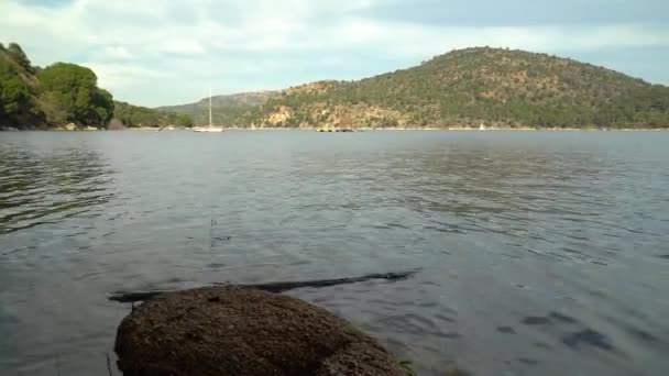 日の出の湖の風景で セーリングボートは水の上を航海し 緑の山々は背景に木があります パンターノ フアン マドリード — ストック動画