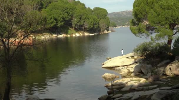 Junge Angelt Einem See Von Einem Felsen Ufer Wirft Seine — Stockvideo