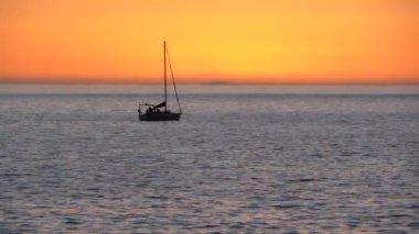 Günbatımı deniz manzaralı, yelkenli bir gemi ve ufukta güneş batıyor. Büyük Kanarya. İspanya.