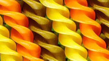 Siyah arka planda pişmemiş üç renkli makarna. Makro yemek fotoğrafı..