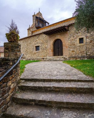 Ancient medieval church made of stone with stair access and tower with balcony. Horcajuelo Madrid. Spain.