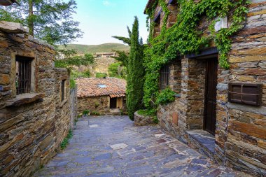 Narrow street in town with old houses and mountain views. Patones de Arriba Madrid. Spain. clipart