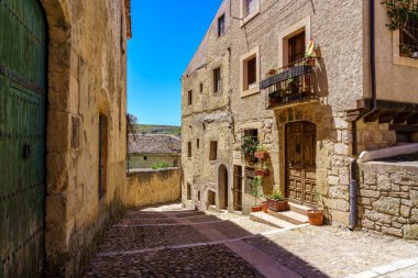 Güneşli bir yaz gününde taş evleri olan dar bir sokak. Sepulveda İspanya.