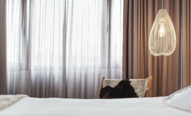 Perdeleri olan oda, ışığı olan lamba ve dinlenmek için yatak. İspanya.