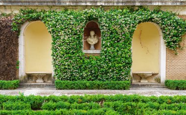 Aranjuez kraliyet sarayının sarmaşık bahçesindeki heykeller ve koltuklar. Madrid.