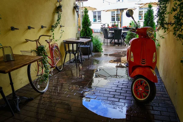 Lovely alley with bike and motorbike after the rain.