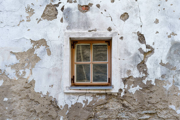 Small window in very old medieval and dilapidated building.