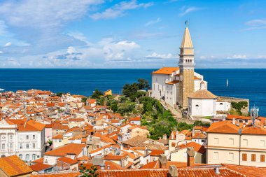 Slovenya 'nın Piran kentinin kıyı kentindeki resimli evlerin üzerinde yükselen Aziz Georges Kilisesi