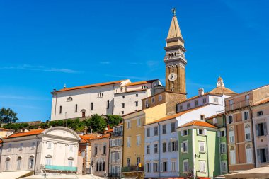 St. Johns Kilisesi 'nin yüksek kulesi Slovenya' nın Piran kentindeki resimli evlerin çatılarından yükseliyor.