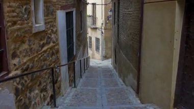 Toledo 'nun anıtsal şehrinde merdivenleri ve çok eski binaları olan dik sokaklar.