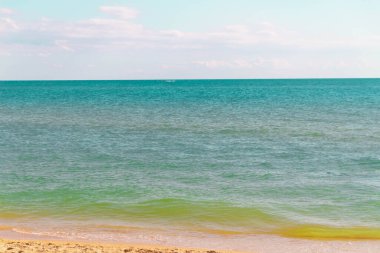 Güzel zümrüt, turkuaz deniz, sarı kum ve küçük dalgalar.