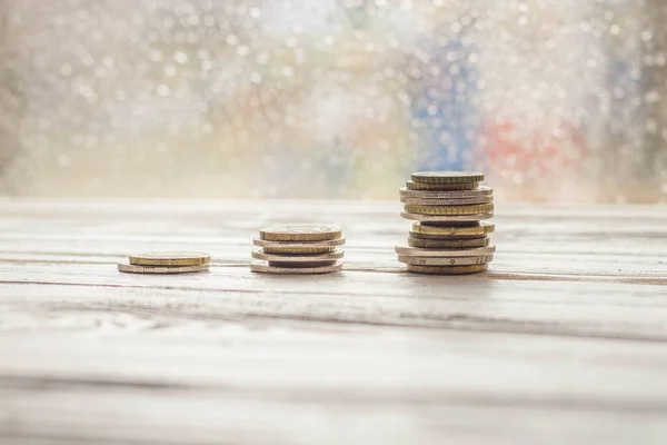 Three stacks of coins on the table. The number of coins increases in each pile.