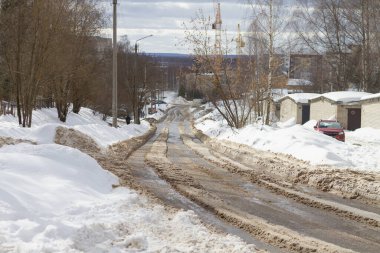 Kışın kasabada dağdaki yolda eriyen karlar..