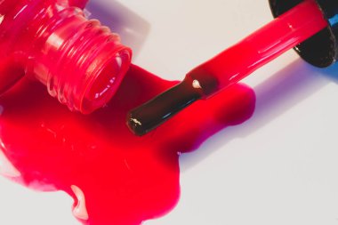 Beyaz bir masaya dökülen parlak kırmızı oje..