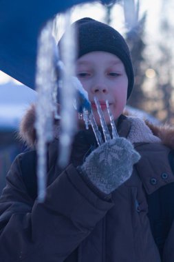 Çocuk elinde buz saçakları tutuyor ve bahar akşamları diliyle buz saçaklarını yalıyor..