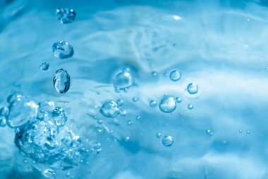 Mavi suyun yüzeyine su damlıyor. Bir damla su..