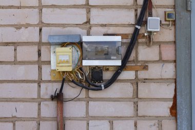 Dışarıdaki evin duvarında yedek güç anahtarları ve elektrik sayacı var..