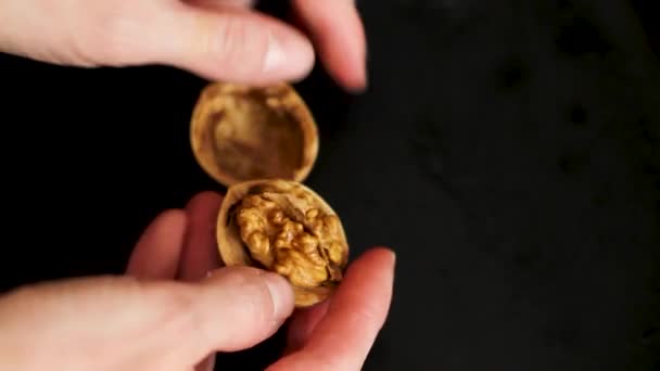 Расколоть грецкий орех сильными руками разбить ореховую скорлупу и вынуть зерна — стоковое видео