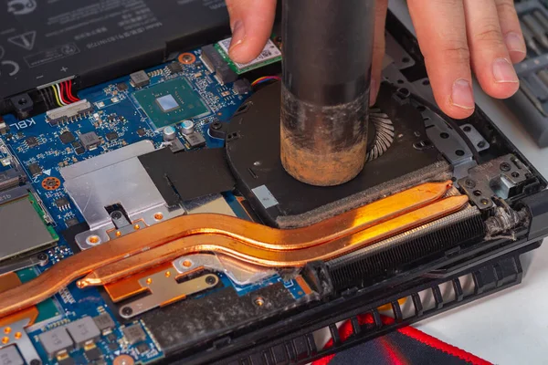 Zdmuchnij pył odkurzaczem z lodówki zdemontowanego laptopa — Zdjęcie stockowe