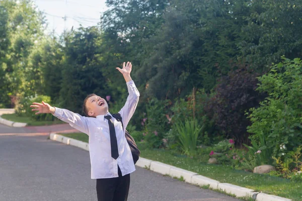 El estudiante está feliz por el final del día escolar y las vacaciones después de la escuela y se ríe — Foto de Stock