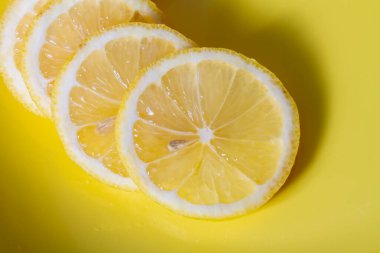 Sarı tabakta dilimlenmiş ekşi meyve limonu..