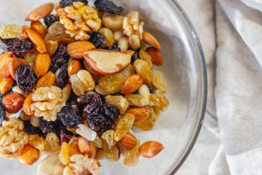 Fındık, kurutulmuş meyve, kuru üzüm, ceviz, fındık, badem, kaju karışımı bir tabak..