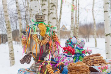 Maslenitsa tatili için semaver ve kreplerle süslenmiş bir masa..