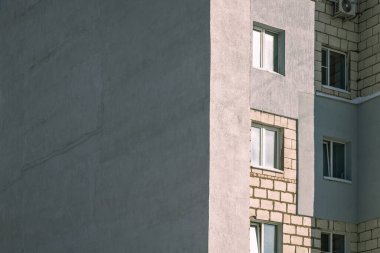 Kışın ayazdan korunmak için köpükle kaplı gri bir duvarı olan çok katlı bir ev. Boşluğu kopyala.