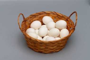 Gri arka planda beyaz tavuk yumurtalı sepet..