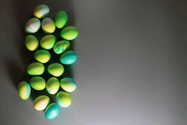 复活节背景 蓝色和绿色复活节彩蛋在灰色桌子的边缘 — 图库照片