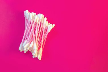 Pembe arka planda beyaz pamuktan yapılmış pamuklu çubuklar..