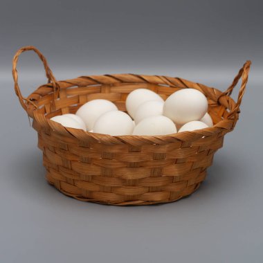 Gri arka planda beyaz tavuk yumurtalı sepet..
