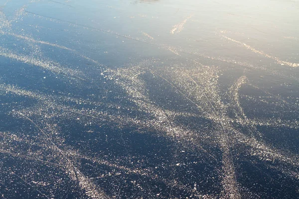 Ice on the river with skate tracks in winter outdoor.