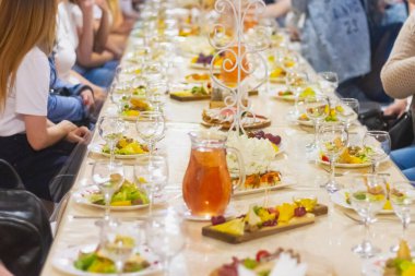 Kafe ziyafeti, Rus bayramı, masa bardaklar, meyveler, salata tabakları ile kaplı..