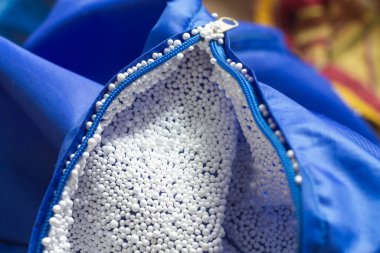 Elektrikli hafif köpük doldurucu fermuara, ellere, mavi kumaşa yapışmış..