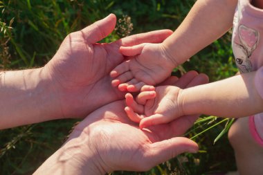 Bebeğin küçük elleri, büyük ellerde, baba ve aile kavramı..
