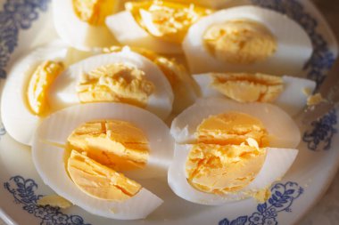 Bir tabakta haşlanmış tavuk yumurtalarını dilimle..