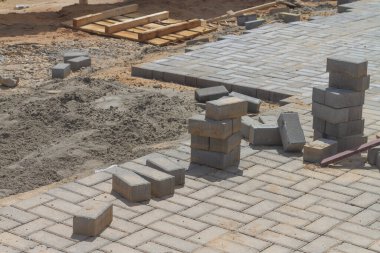 Şehrin kaldırımlarına kaldırım döşeme döşemesi yapım aşamasındaki yeni bir evin yanında..