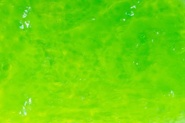 Hava kabarcıkları ile şeffaf balçıktan yapılmış soyut parlak yeşil arkaplan.