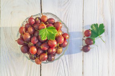 Böğürtlen üzümleri, tahta bir arka planda cam bir tabakta bektaşi üzümleri toplanır..