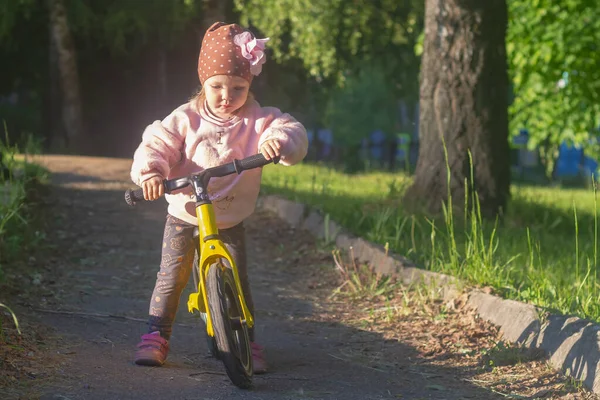 Милая Белая Девочка Шляпе Цветком Учится Кататься Велосипеде Беговой Дорожке — стоковое фото