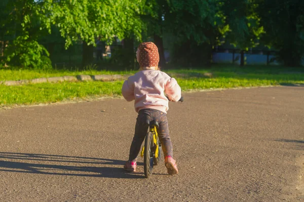 Милая Белая Девочка Шляпе Цветком Учится Кататься Велосипеде Беговой Дорожке — стоковое фото