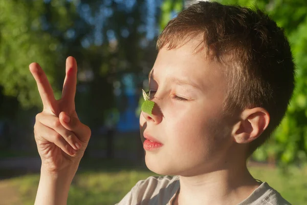 一个温暖的晴天 一只蝴蝶栖息在一个少年的鼻子上 — 图库照片