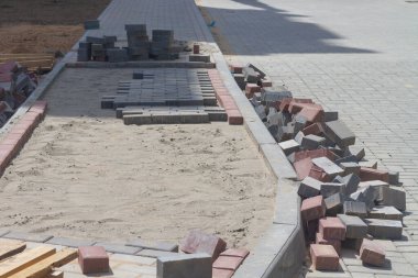 İşçiler kaldırıma döşeme döşeme döşeme döşeme döşeme bir iskan bina yanında.