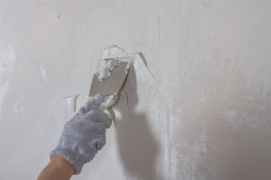 Duvarı beyaz alçı macunuyla boyadan önce metal bir spatula ile macunlayın ve duvar kağıdı yapıştırın..