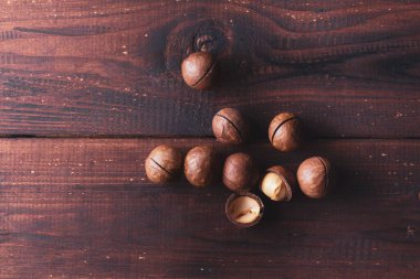Kahverengi ahşap bir masada Macadamia fındıkları.